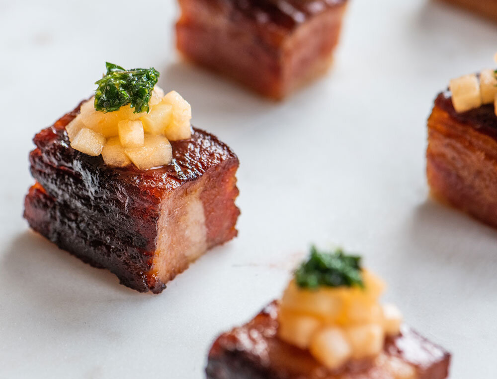 Artisanal sugar-glazed pork belly bites with mango slaw served as passed appetizers by Joel Catering, New Orleans' premiere caterer