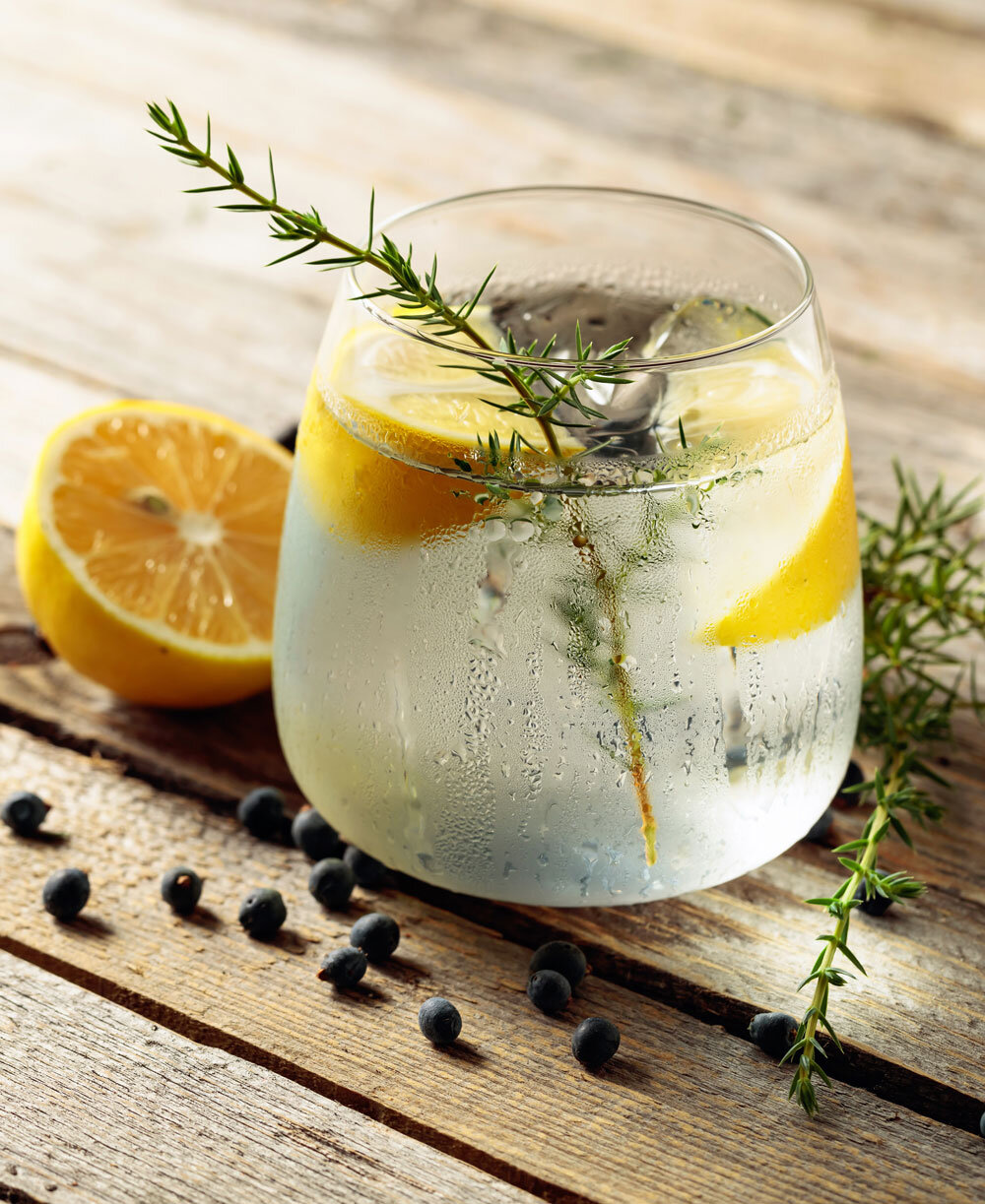 Stemless teardrop-shaped glass of ice water with lemon and rosemary garnish, embodying Joel Catering's organic and natural presentation style in New Orleans