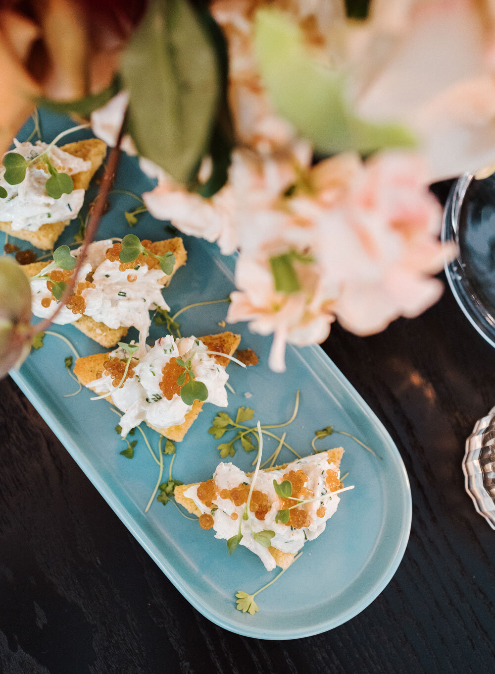 Exquisite triangle toast points topped with fresh lump crab salad, roe, and fresh herbs, a premium seafood passed appetizer by Joel Catering in New Orleans.